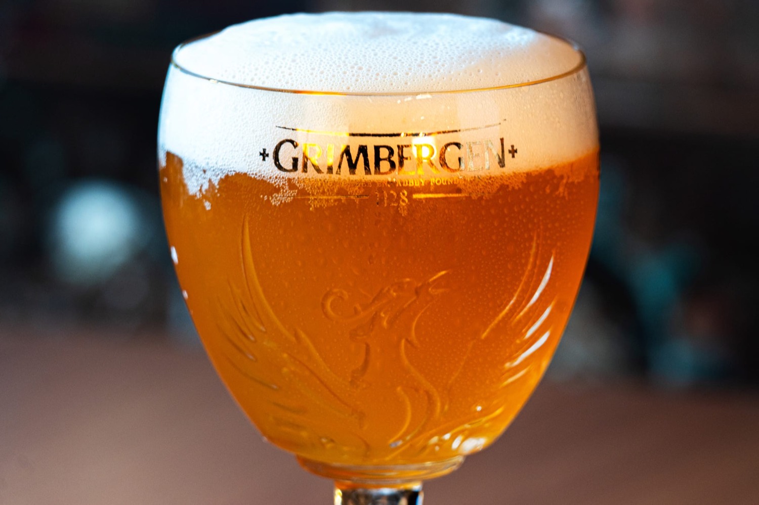 Calice Grimbergen ambrata retroilluminato, schiuma dorata — Domas Pub Torvaianica